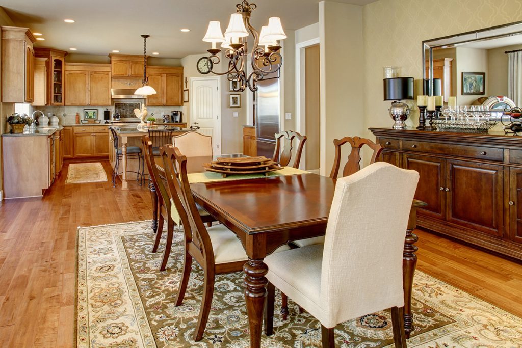 A dining room table on an oriental rug with a kitchen rug visible in the background. Protect your hardwood floors this Thanksgiving.