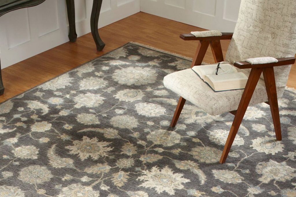 Brown and cream traditional oriental rug beneath a chair.
