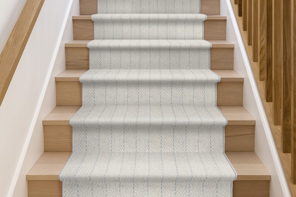 A camel and taupe stair runner with thin blue vertical lines down.