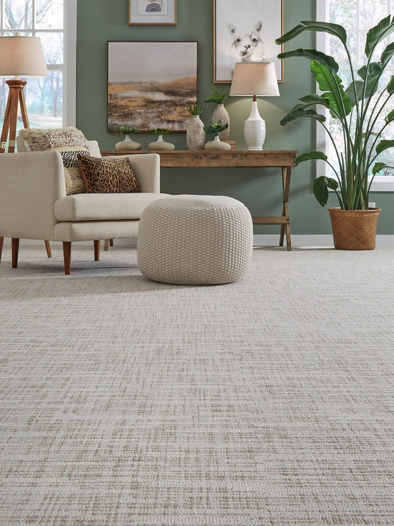 A gray textured carpet with a green wall.