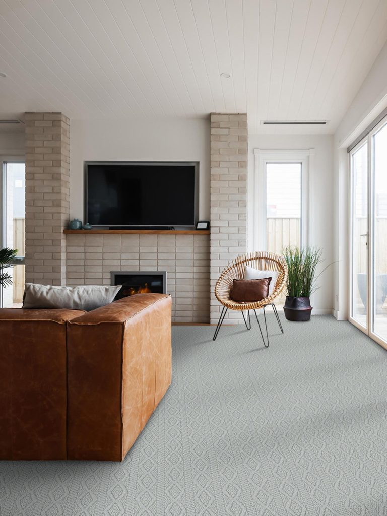 A light blue broadloom carpet with a brown couch and chair.