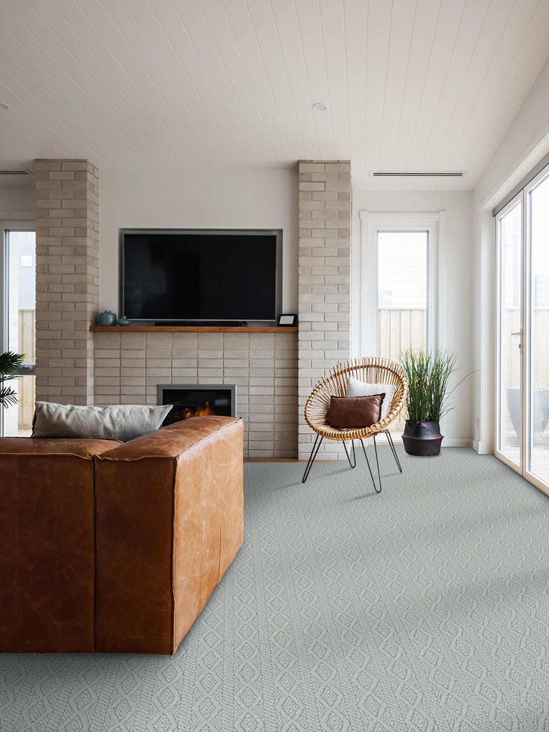 A light blue broadloom carpet with a brown couch and chair.