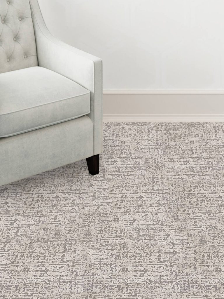 A gray patterned carpet beneath a chair.