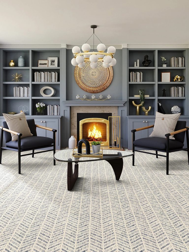 A white and gray patterned broadloom carpet with blue bookshelves and a fireplace.