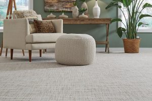 Gray textured broadloom carpet with a gray chair and green wall.