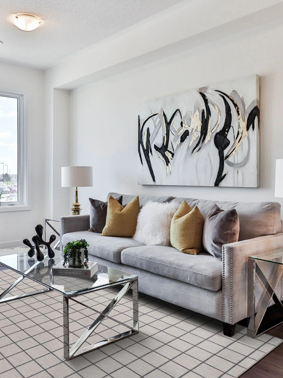 A light checkered carpet by Prestige Mills under a a gray couch and glass table.