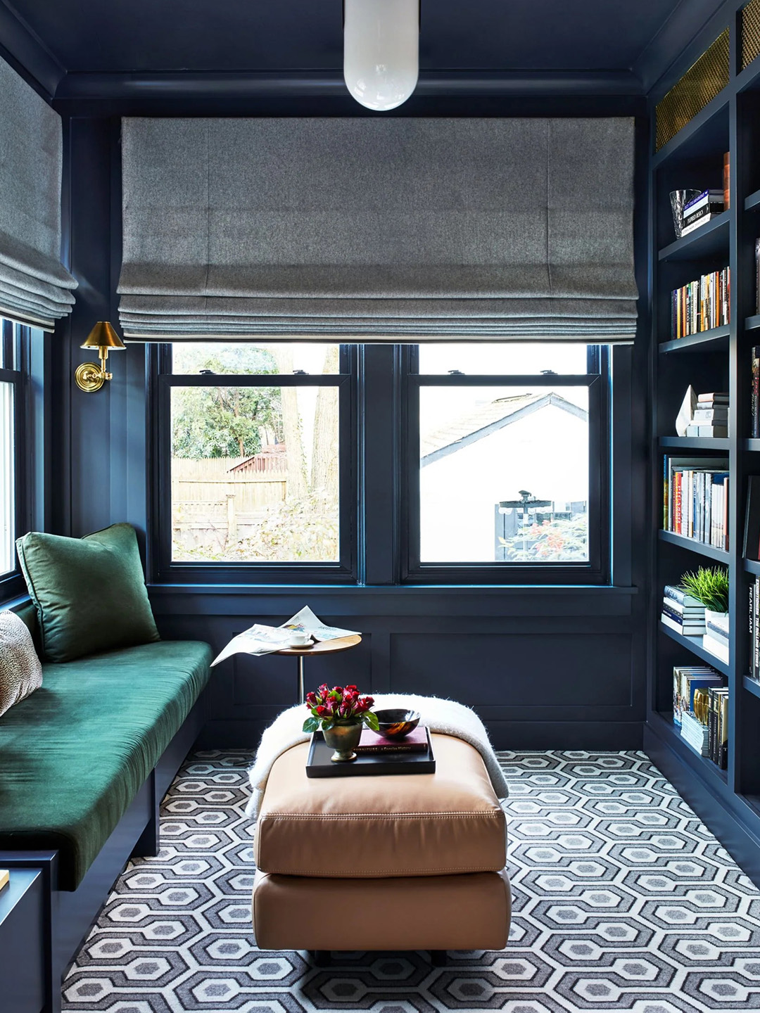A dark blue patterned carpet by Prestige Mills with blue walls, a green sofa, and a brown coffee table.