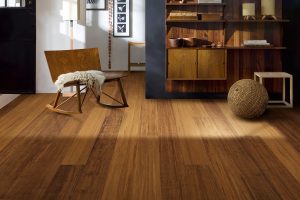 Brown bamboo flooring with a wood chair and built-in shelving in the background.
