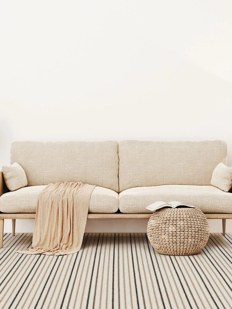 Striped carpet under a white sofa.