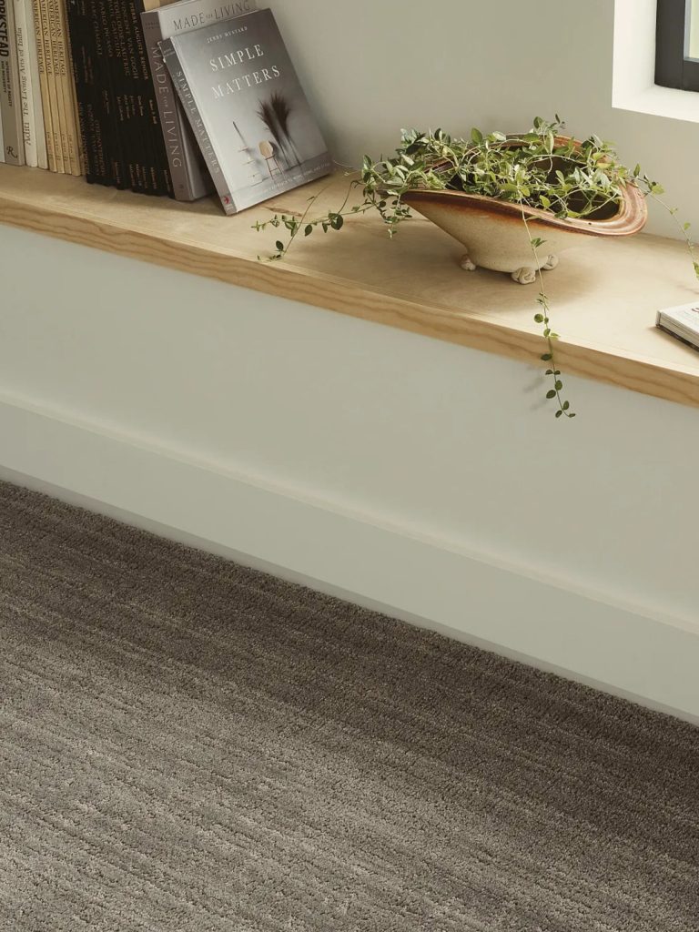 A brown patterned carpet against a white wood bench for our spring carpet inspo.