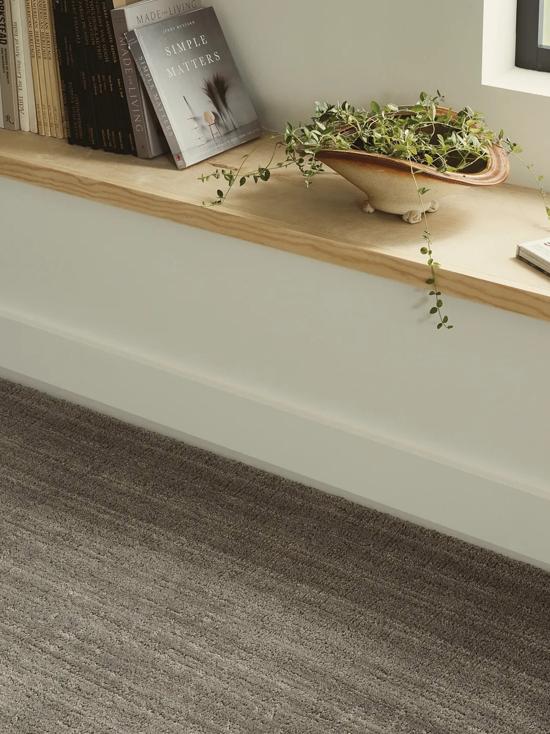 A brown patterned carpet against a white wood bench for our spring carpet inspo.