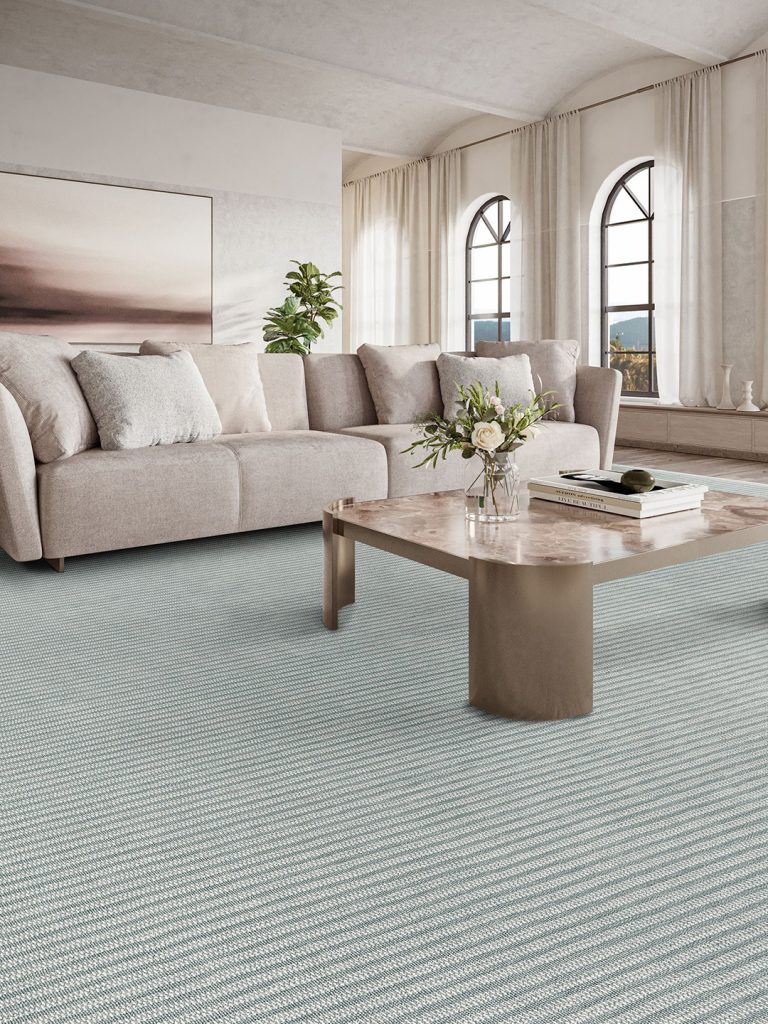 Light blue striped carpet with a beige couch and coffee table for our spring carpet inspo.