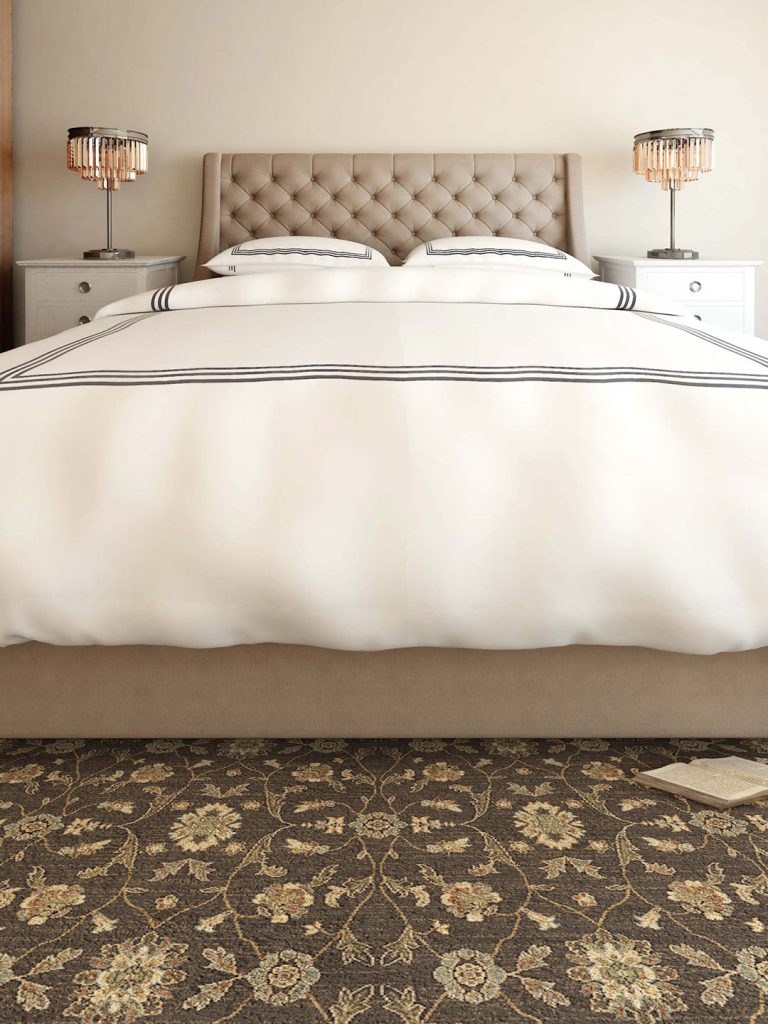 An antique-looking patterned carpet against a white bed for our spring carpet inspo.