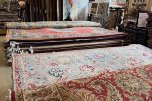 Stacks of new oriental rugs in a variety of colors and designs on display to advertise full service rug cleaning.