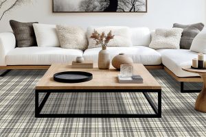 A white and grey checkered carpet beneath a wood coffee table and white sofa.