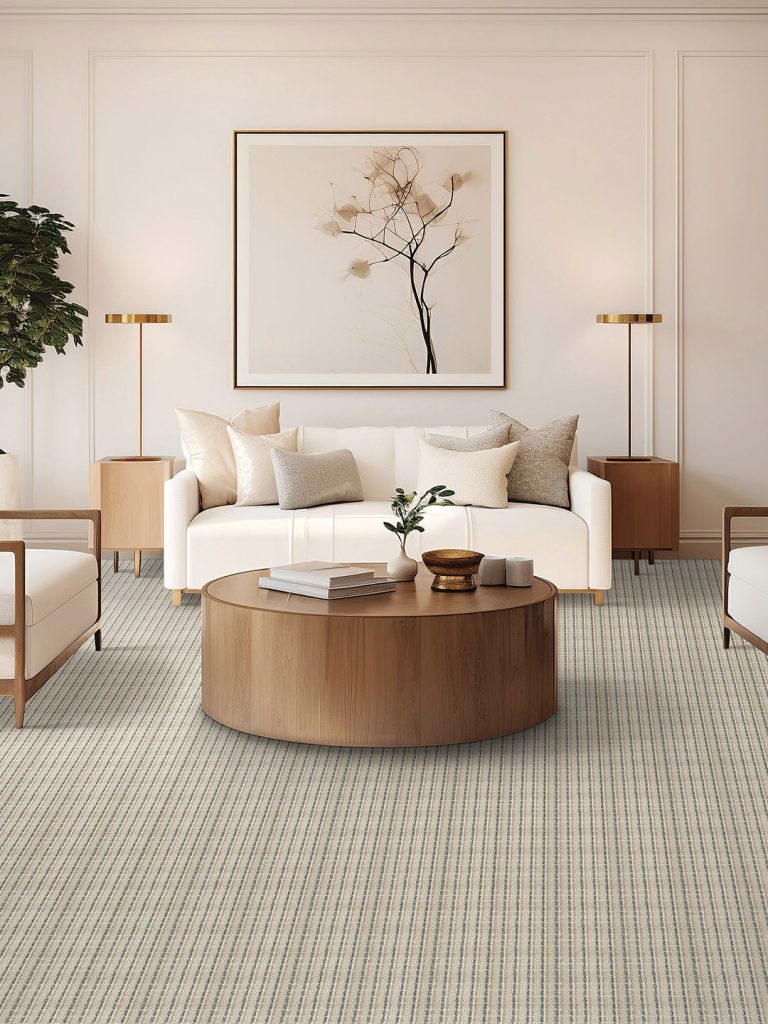 A neutral colored striped carpet in a living room setting with a white couch and wood table.