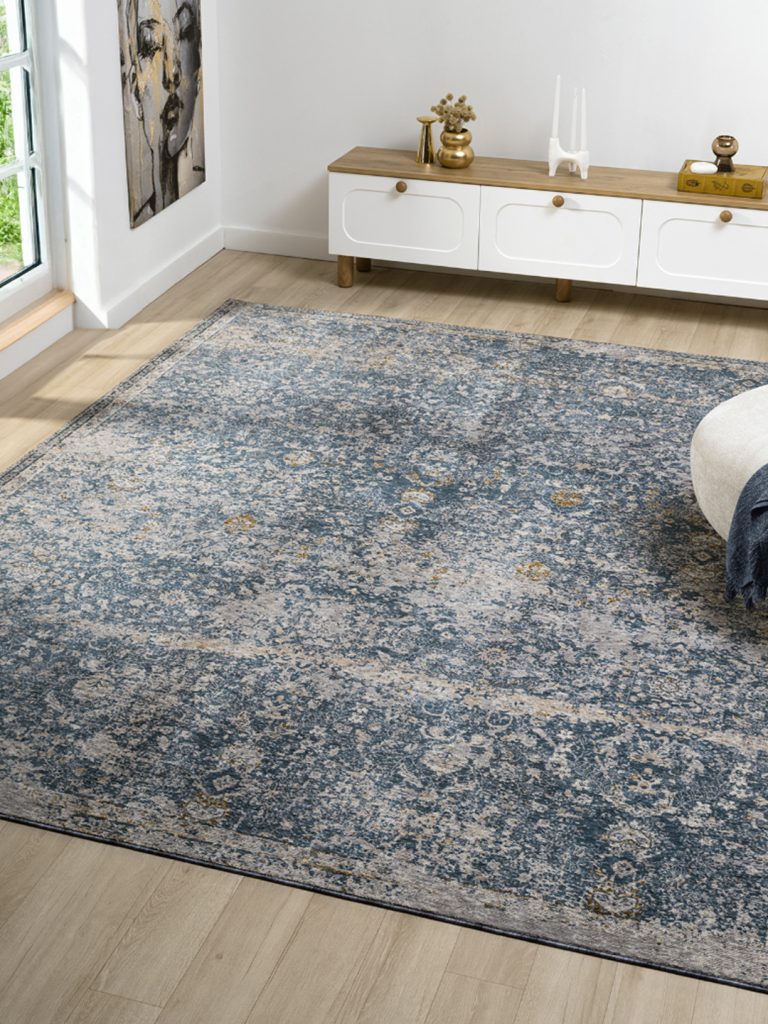 A predominantly blue machine-made rug in a living room setting.