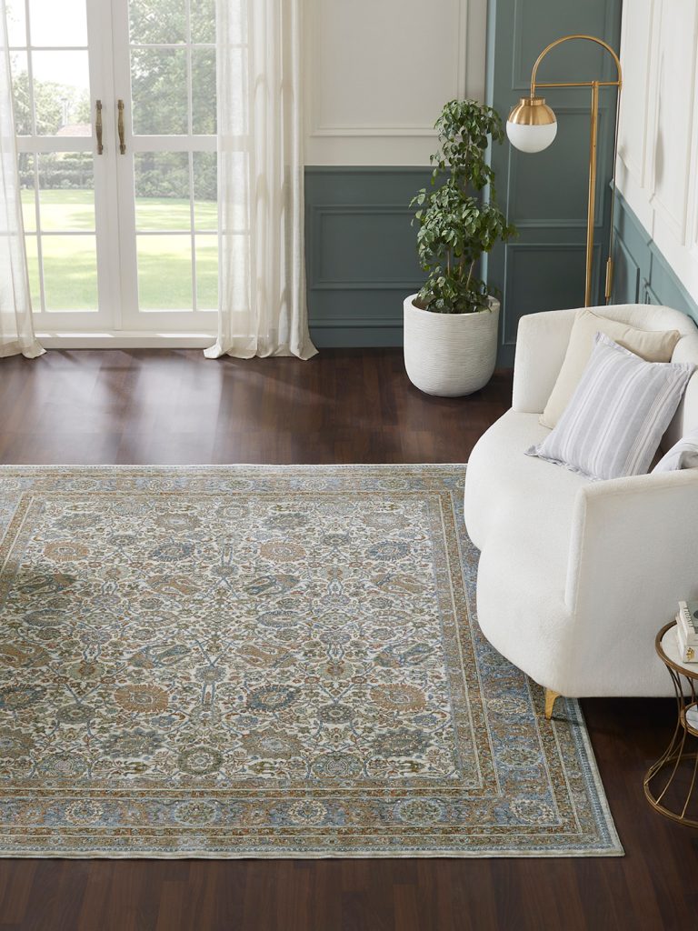 A multicolored patterned machine-made rug in a living room setting.