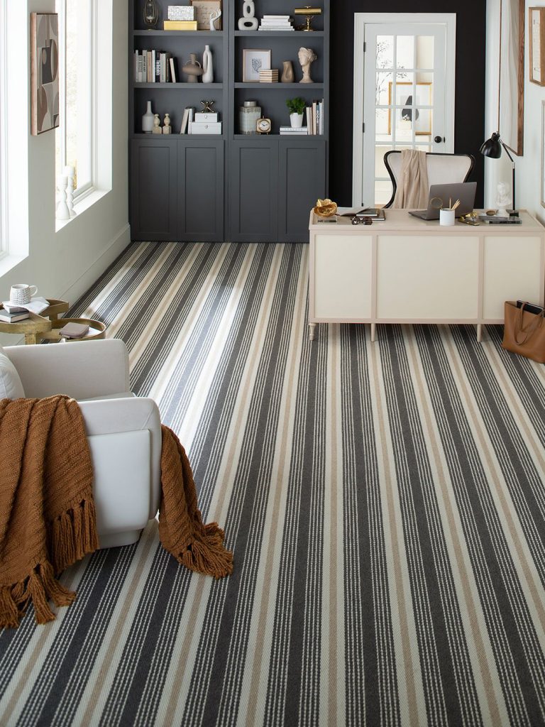 A cream and gray striped residential carpet of various widths in a neutral home office setting.