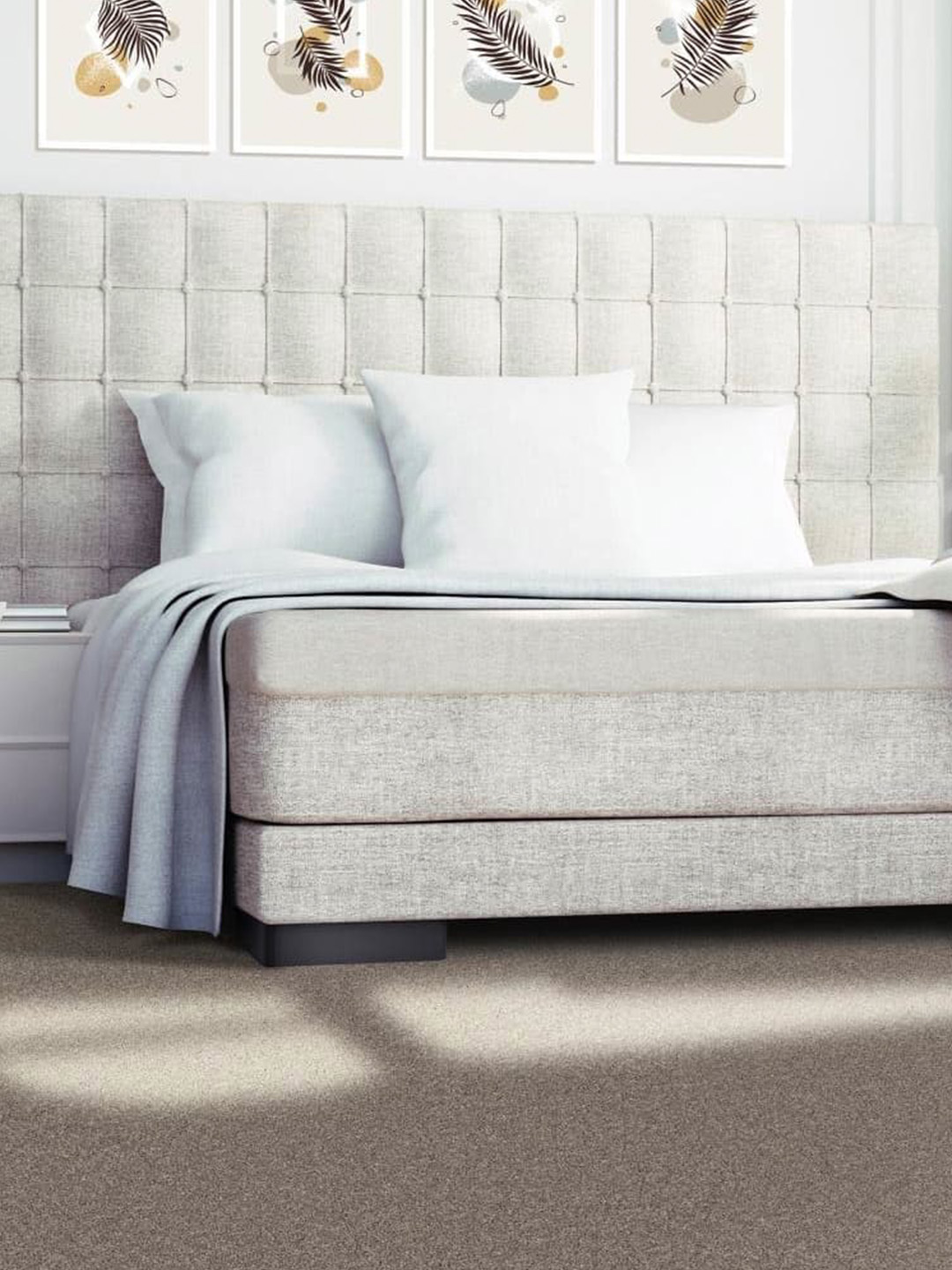 Brown residential carpet beneath a gray and white bed.