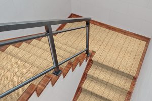A beige stair runner rug with a subtle geometric pattern and an iron handrail.