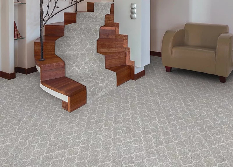 A gray and white carpet that extends up the stairs to advertise our Couristan rug and carpet sale.