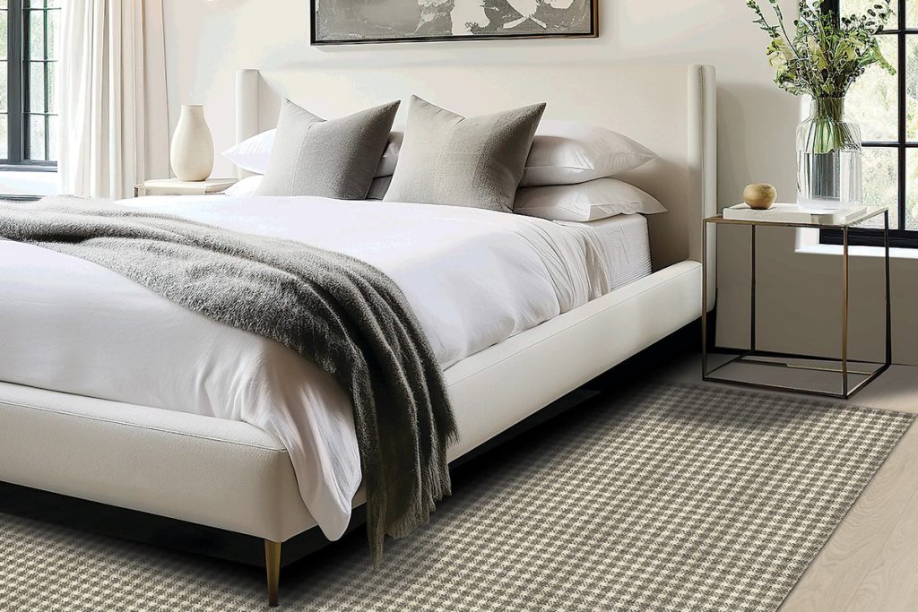 A checkered Karastan Black Label rug beneath a bed to highlight our Summer Sizzler Rug Sale.