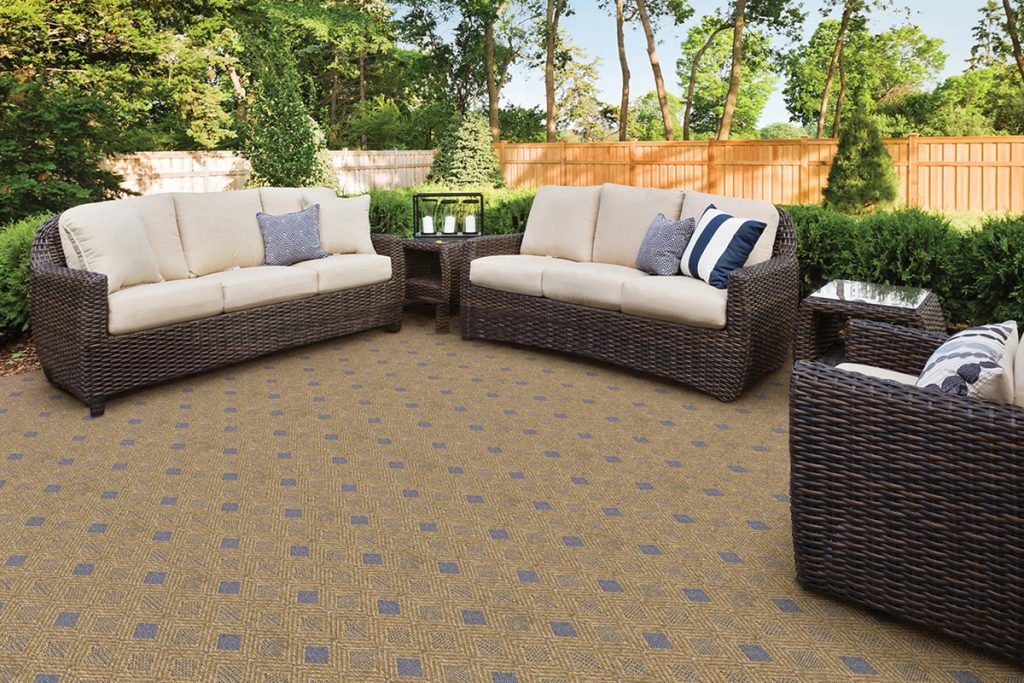 A gold and blue diamond patterned carpet in an outdoor patio setting.