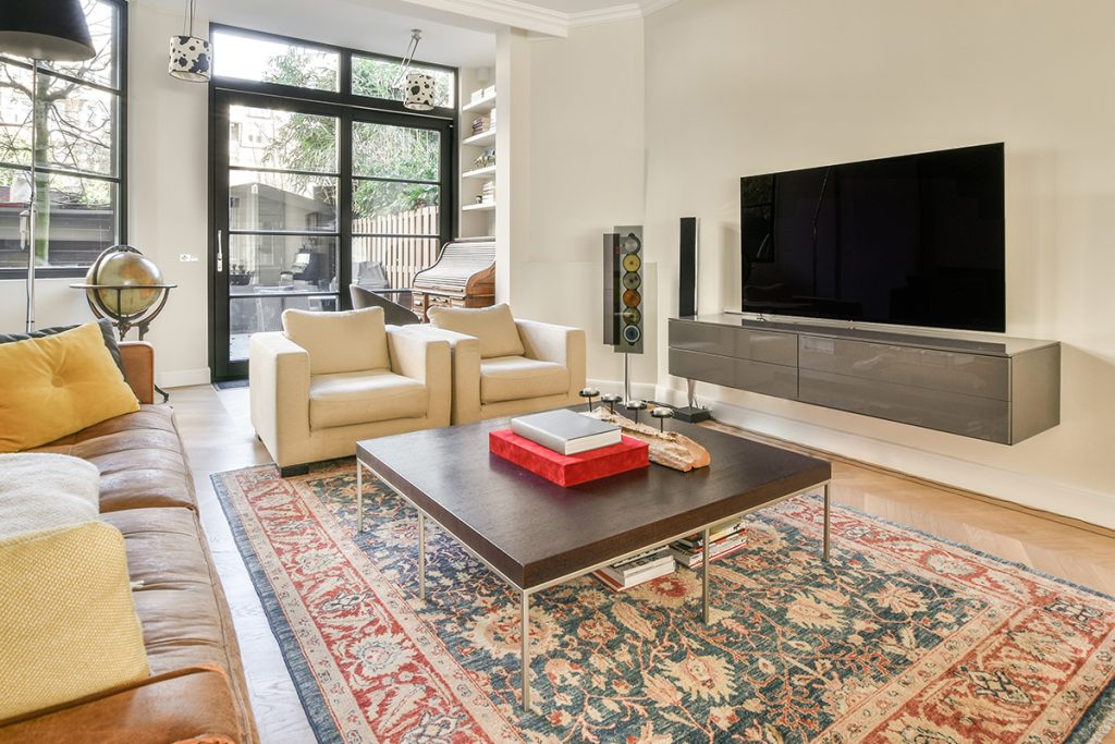 A large oriental rug beneath a coffee table in a living room setting to market our final summer clearance sale.