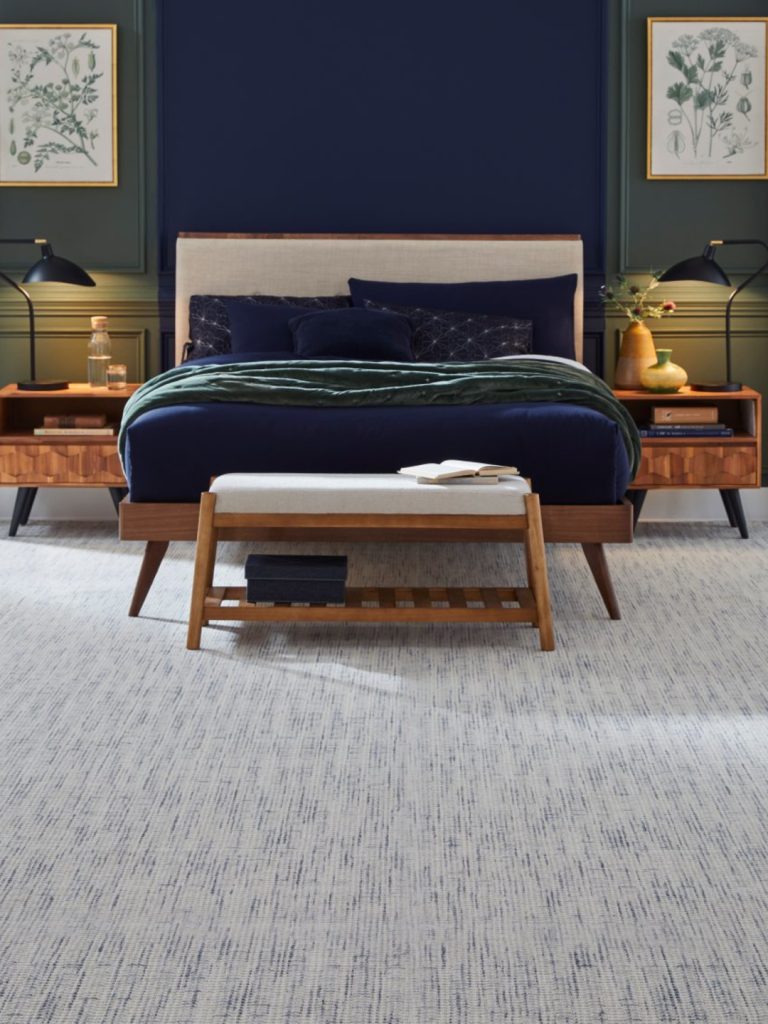 A gray carpet with subtle blue color striations by Masland in a bedroom setting 