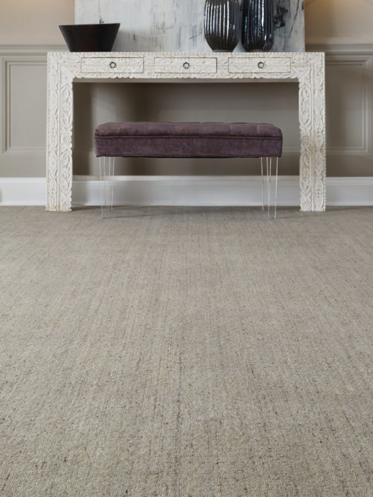 A heathered carpet by Masland with a bench and table against the wall 